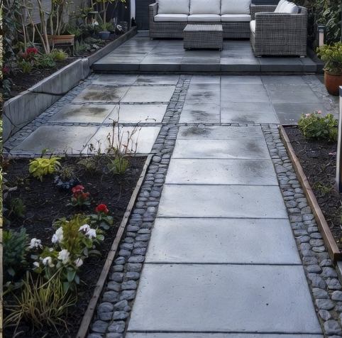 Strak betegeld terras met grote grijze tegels, kinderkopjes-accenten en borders vol beplanting, na een complete tuinaanleg
