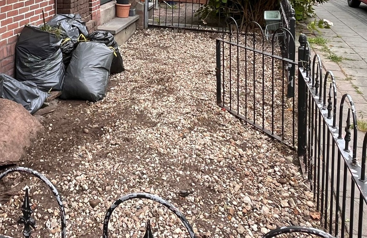 De opgeruimde voortuin na het werk: schone, wortelvrije grond, klaar voor een groene herinrichting