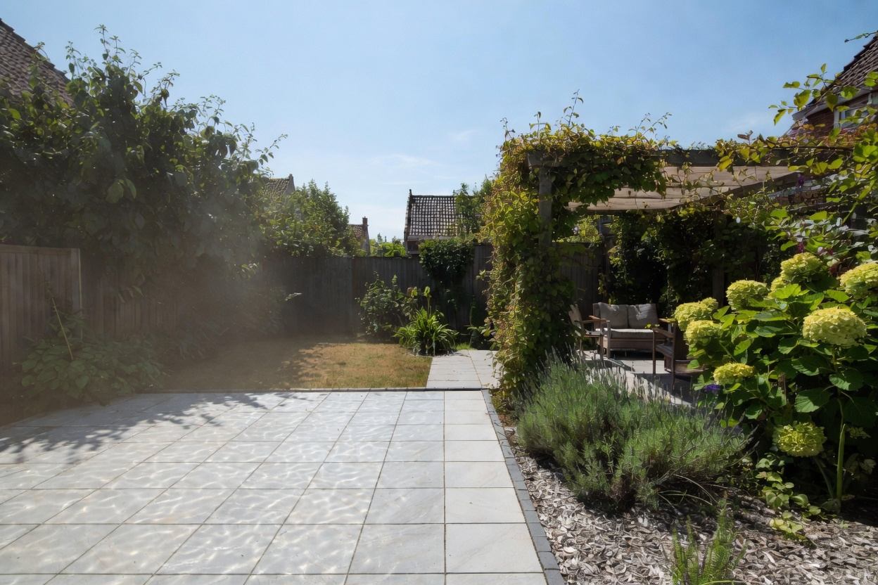 Zonnige tuin met een begroeide pergola die schaduw geeft, lavendel en hortensia's langs het terras — groen dat de tuin op warme zomerdagen koel houdt