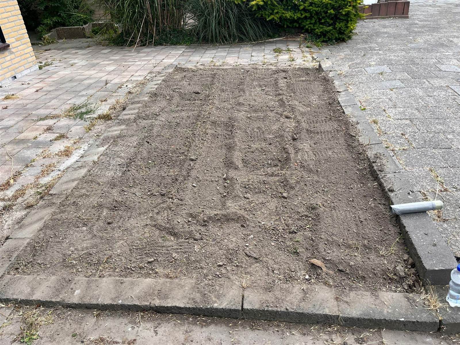 Dezelfde border na het onkruid verwijderen: schone, geëgaliseerde grond klaar voor beplanting